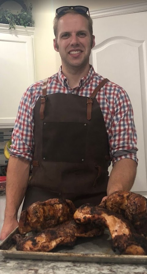 Russell, the pitmaster behind Rusty's, with a tray of smoked chickens