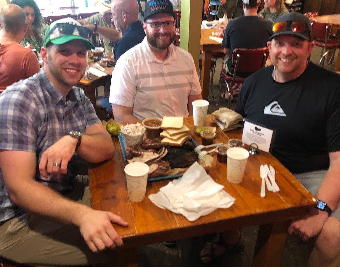 Russell and friends around a tray of barbecue