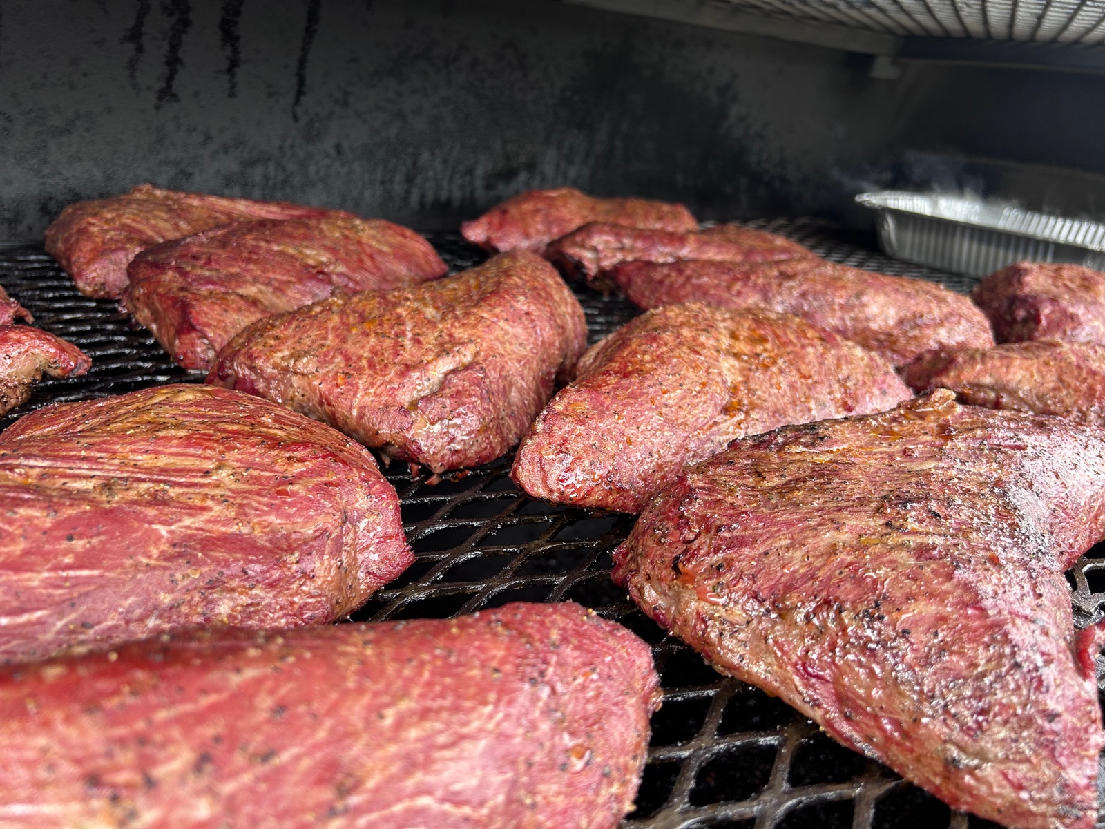 Seasoned tri tip roasts on the smoker